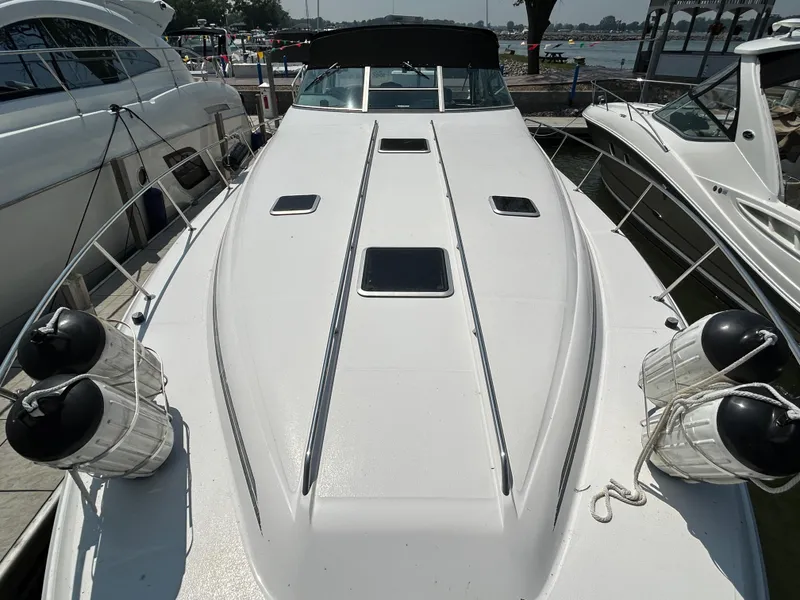 Slide: The Image of 1993 Sea Ray 440 Sundancer yacht docked, showcasing sleek white deck and fenders. - 11