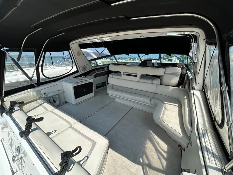 Slide: The Image of Spacious interior of 1993 Sea Ray 440 Sundancer yacht with white seating and panoramic windows. - 14