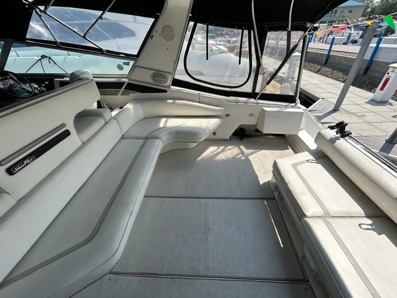 Slide: The Image of Interior seating of 1993 Sea Ray 440 Sundancer yacht, featuring white cushioned benches. - 18