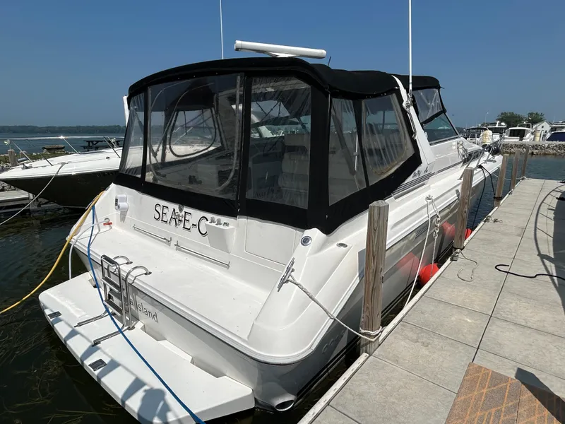 Slide: The Image of 1993 Sea Ray 440 Sundancer docked at marina, featuring black canopy and white hull. - 2