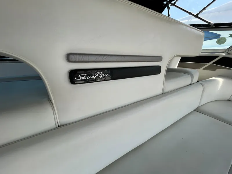 Slide: The Image of 1993 Sea Ray 440 Sundancer cockpit with white seating and helm, docked at marina. - 20