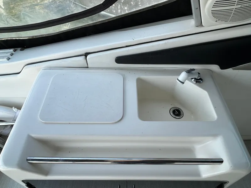 Slide: The Image of 1993 Sea Ray 440 Sundancer boat interior with white cushioned seating. - 24