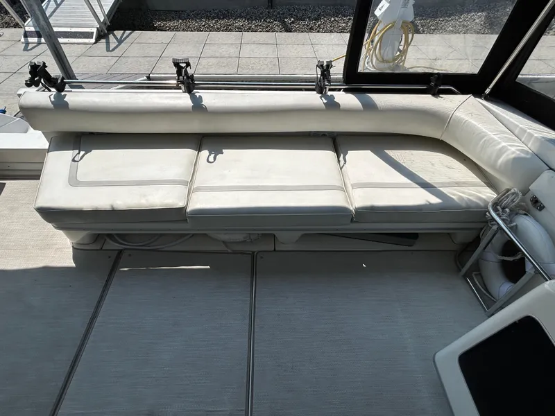 Slide: The Image of 1993 Sea Ray 440 Sundancer interior with white seating and deck view. - 25