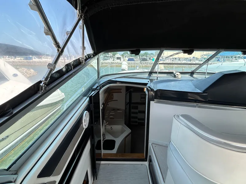 Slide: The Image of Interior of 1993 Sea Ray 440 Sundancer yacht with white seating and helm area. - 28