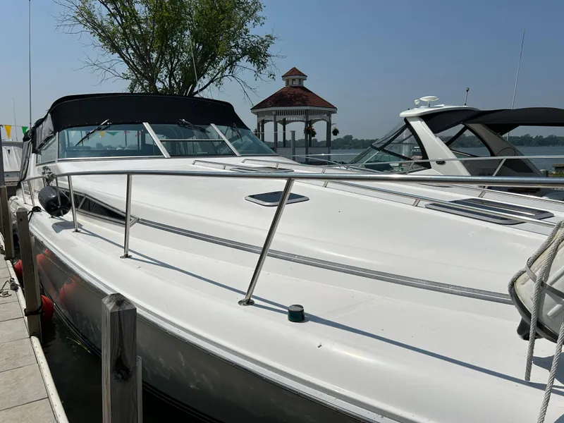 Slide: The Image of 1993 Sea Ray 440 Sundancer docked, featuring sleek white design and spacious deck. - 6