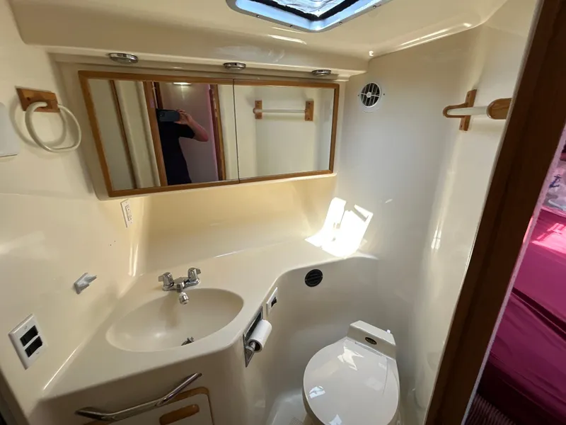 Slide: The Image of Interior of 1993 Sea Ray 440 Sundancer yacht with beige seating and storage cabinets. - 66