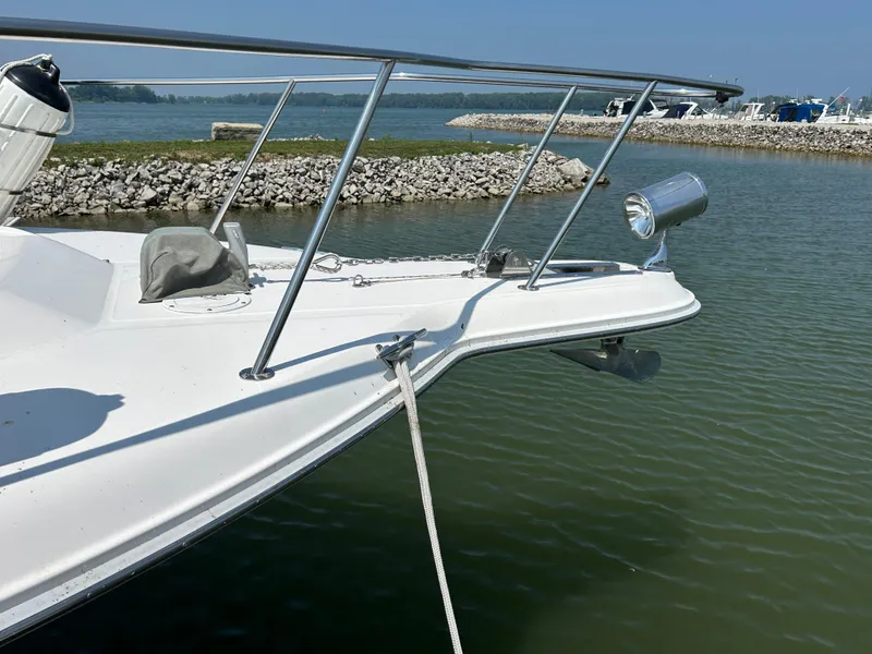 Slide: The Image of Bow of a 1993 Sea Ray 440 Sundancer yacht docked by a rocky shoreline. - 7