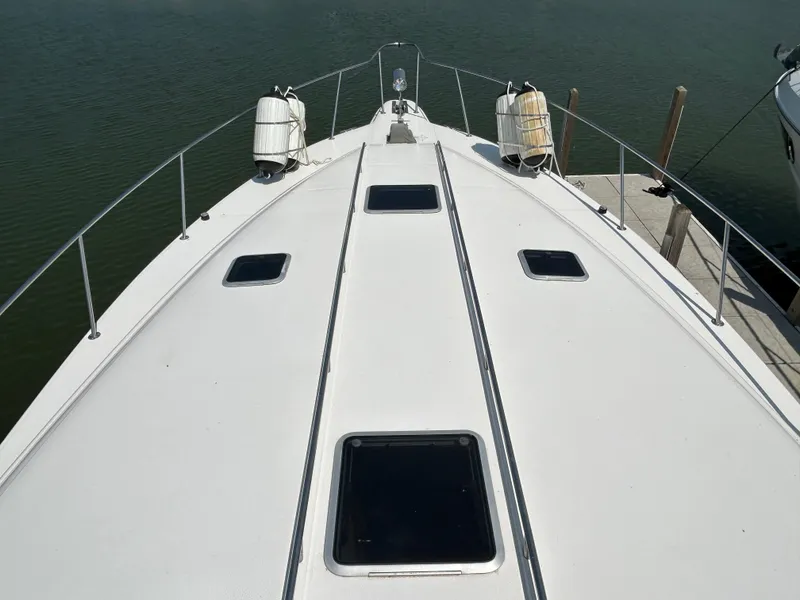 Slide: The Image of 1993 Sea Ray 440 Sundancer yacht deck with hatches, docked on calm water. - 9