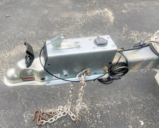 Slide: The Image of Trailer hitch of a 1990 Corsair F27 with safety chains on asphalt. - 19