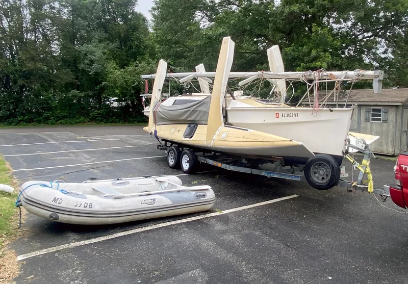 Slide: The Image of 1990 Corsair F27 trimaran on trailer with inflatable boat in parking lot. - 4