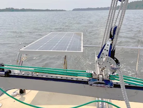 Slide: The Image of Sailboat Corsair F27 (1990) with solar panel on deck, sailing on calm waters. - 8