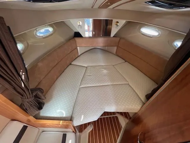 Slide: The Image of 2016 Cutwater 26 cabin interior with cozy bed and elegant wood finish. - 12