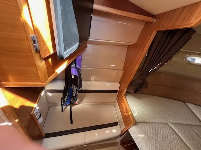 Slide: The Image of Interior of a 2016 Cutwater 26 boat, featuring wooden cabinetry and seating area. - 13