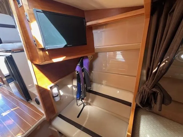 Slide: The Image of 2016 Cutwater 26 interior with TV, seating, and life jacket. - 14