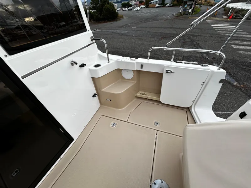 Slide: The Image of 2016 Cutwater 26 boat deck with beige flooring and white railing. - 16