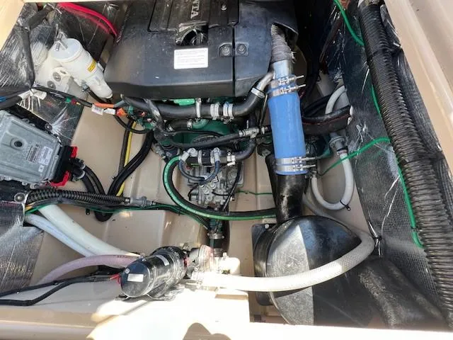 Slide: The Image of Engine compartment of a 2016 Cutwater 26 boat, showcasing various mechanical components and hoses. - 17