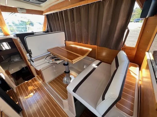 Slide: The Image of 2016 Cutwater 26 interior with wood accents, dining table, and seating area. - 4