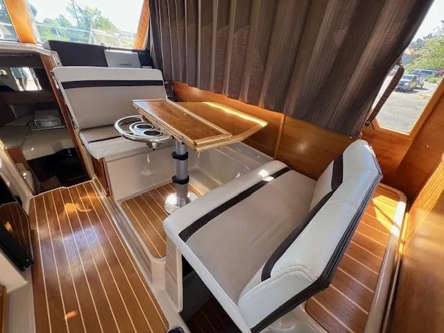 Slide: The Image of Interior of a 2016 Cutwater 26 boat with seating and a wooden table. - 5