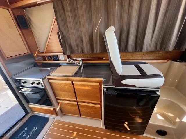 Slide: The Image of Interior of 2016 Cutwater 26 boat with kitchen and seating area. - 8