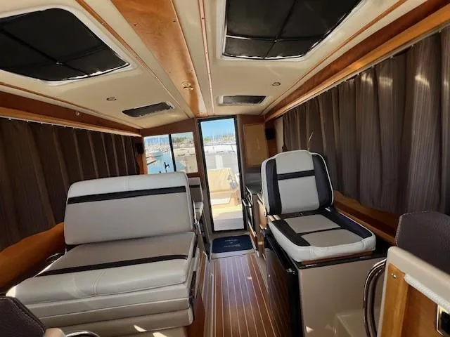 Slide: The Image of Interior of a 2016 Cutwater 26 boat with luxurious seating and wood accents. - 9