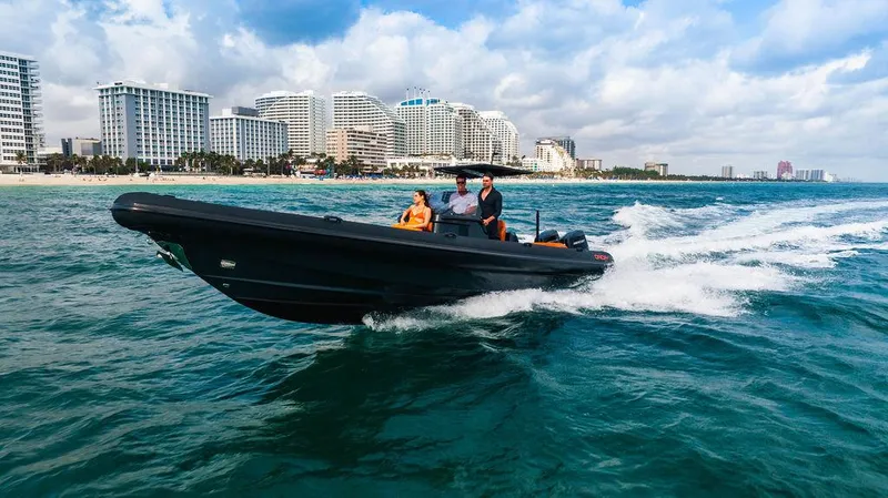 Slide: The Image of 2025 Onda Magna boat cruising near a city shoreline under a partly cloudy sky. - 14