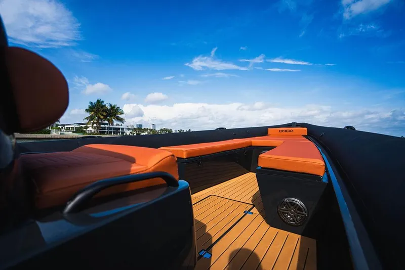 Slide: The Image of Luxurious 2025 Onda Magna boat with orange seating, wooden deck, and scenic ocean view. - 8