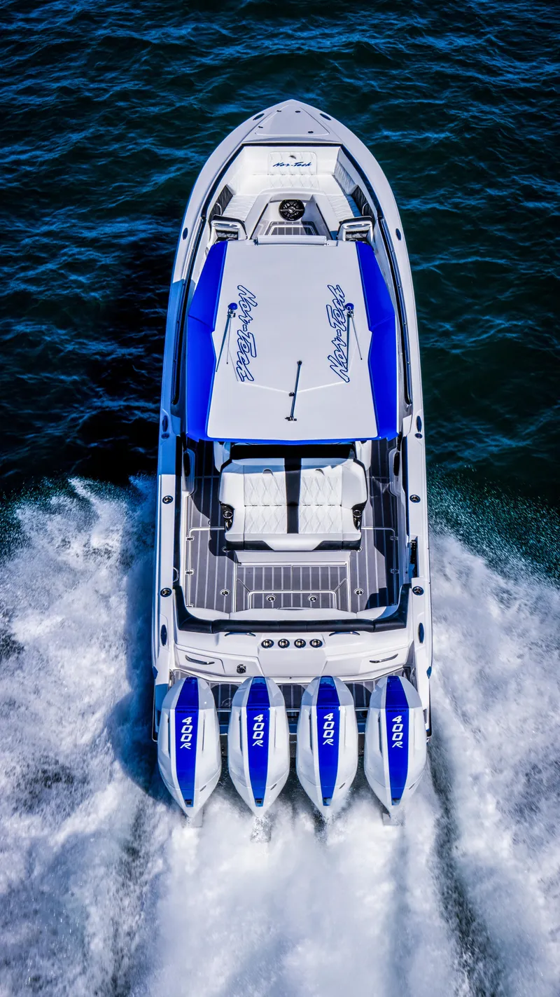 Slide: The Image of 2024 Nor-Tech 400 Supersport boat cruising on water, top view, four powerful engines. - 10