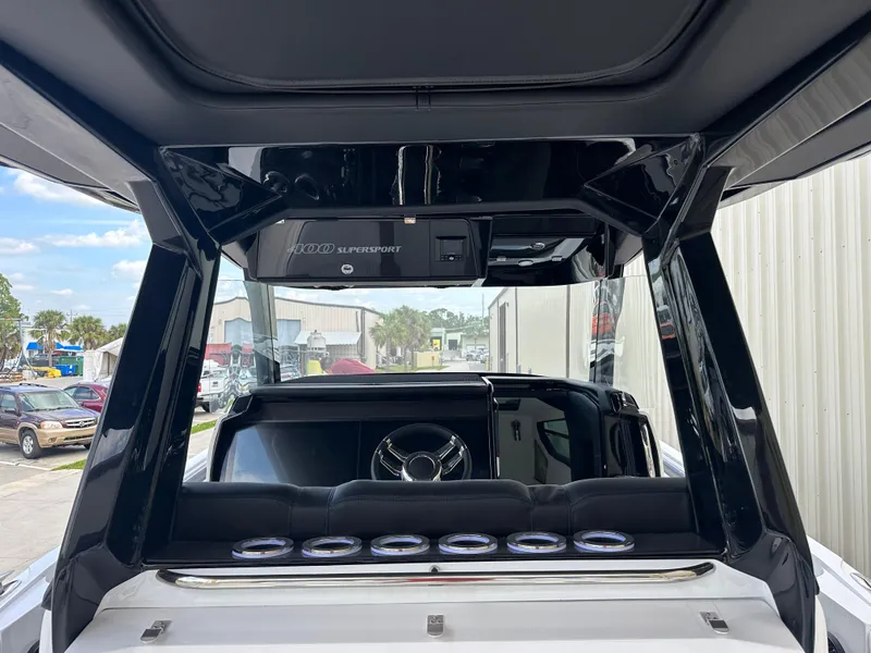 Slide: The Image of 2024 Nor-Tech 400 Supersport boat interior with sleek black design and modern steering wheel. - 12