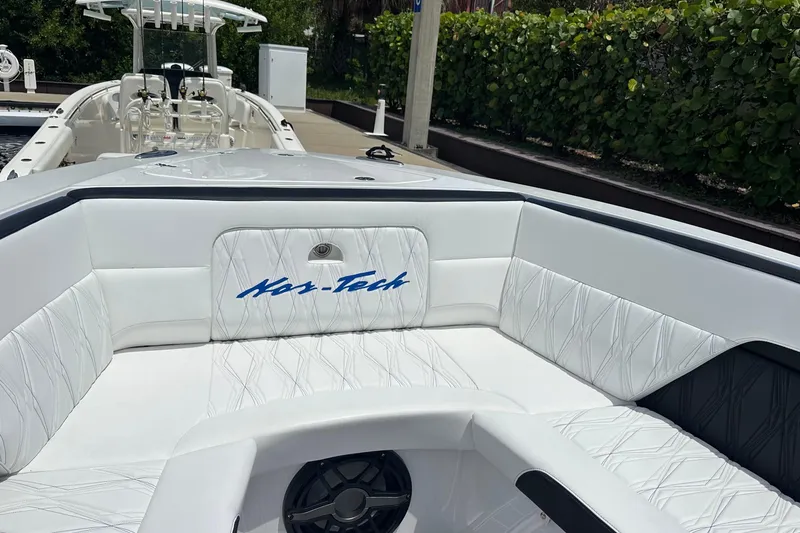 Slide: The Image of 2024 Nor-Tech 400 Supersport boat interior with white seating and logo. - 42