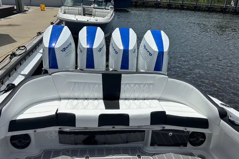Slide: The Image of 2024 Nor-Tech 400 Supersport boat with four powerful outboard engines, docked by the water. - 49