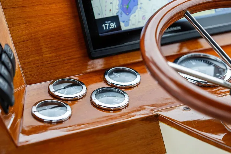 Slide: The Image of 1998 Hinckley Picnic Boat dashboard with wooden steering wheel and navigation instruments. - 29