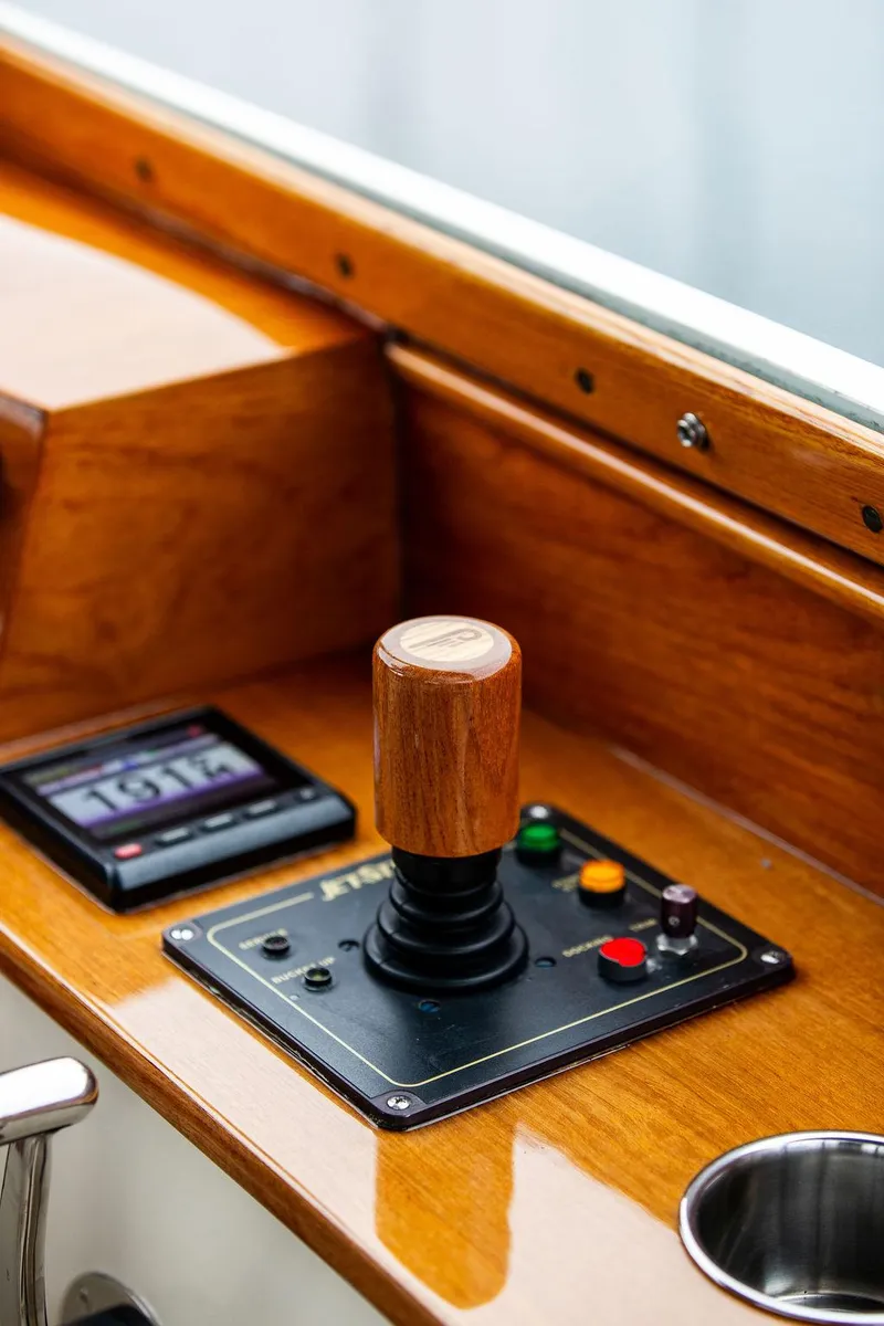 Slide: The Image of 1998 Hinckley Picnic Boat control panel with joystick and display, featuring wooden finish. - 31