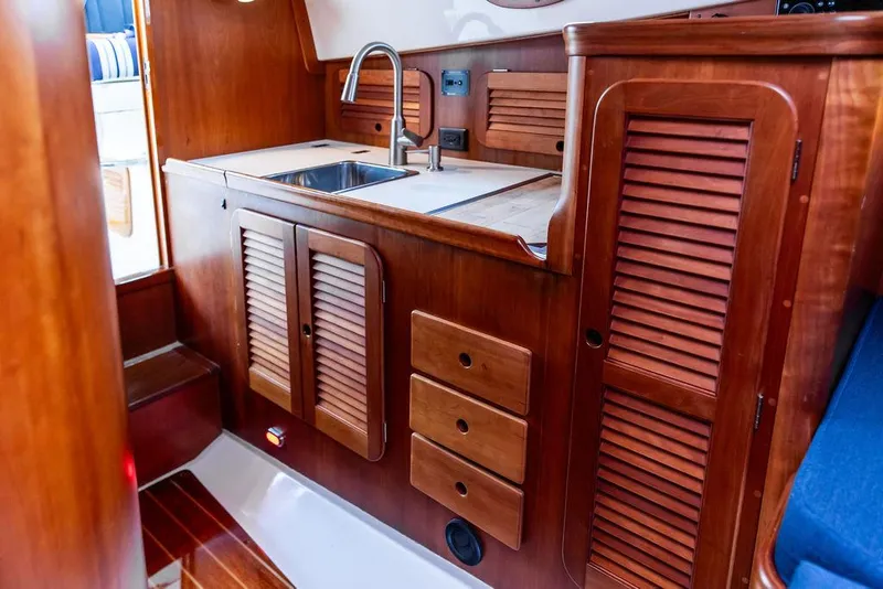 Slide: The Image of Interior of 1998 Hinckley Picnic Boat with wooden cabinetry and stainless steel sink. - 35
