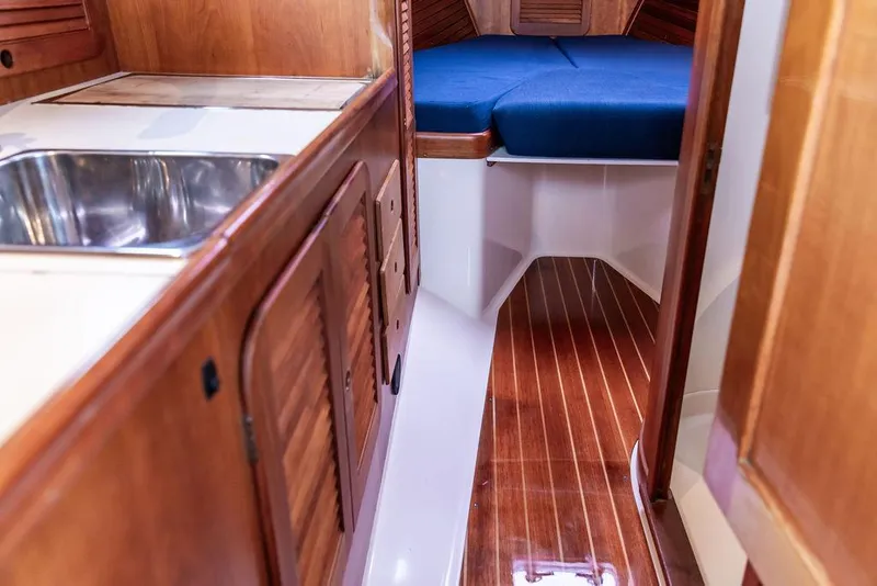 Slide: The Image of Interior of a 1998 Hinckley Picnic Boat with wooden cabinetry and a cozy sleeping area. - 36
