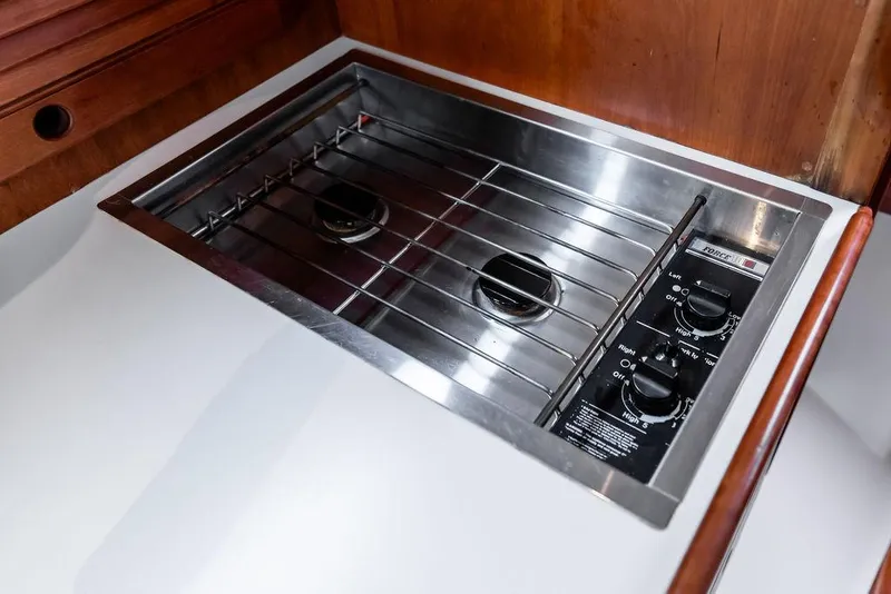 Slide: The Image of Stainless steel stove in 1998 Hinckley Picnic Boat galley, featuring dual burners and control knobs. - 37