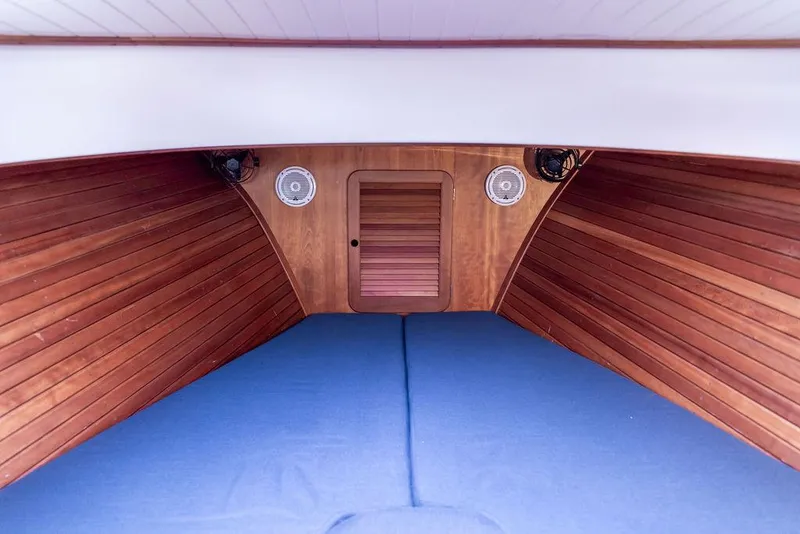 Slide: The Image of Interior of 1998 Hinckley Picnic Boat with wooden paneling and blue cushions. - 38