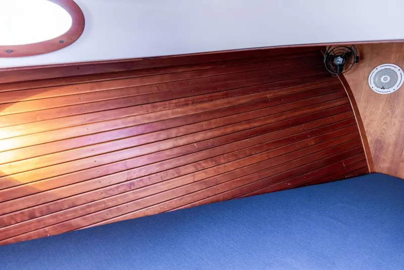 Slide: The Image of Interior of a 1998 Hinckley Picnic Boat with wooden paneling and blue upholstery. - 39