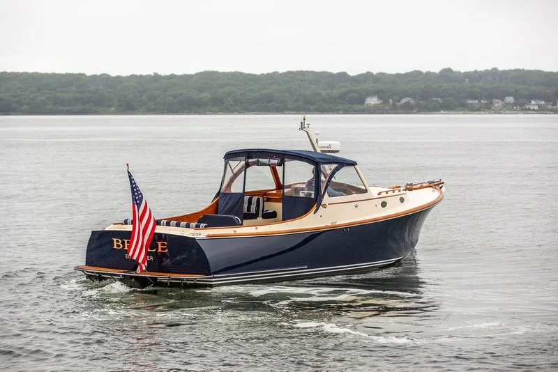 Slide: The Image of 1998 Hinckley Picnic Boat cruising on calm waters with American flag. - 4