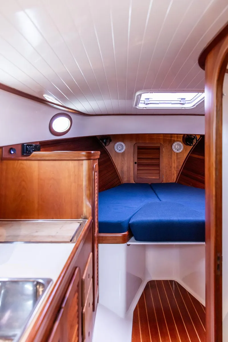 Slide: The Image of 1998 Hinckley Picnic Boat interior with wooden finish and blue cushioned seating. - 42