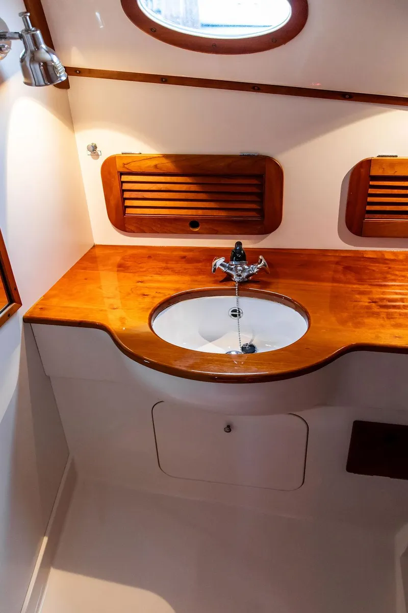 Slide: The Image of 1998 Hinckley Picnic Boat bathroom with wooden countertop and sink. - 45