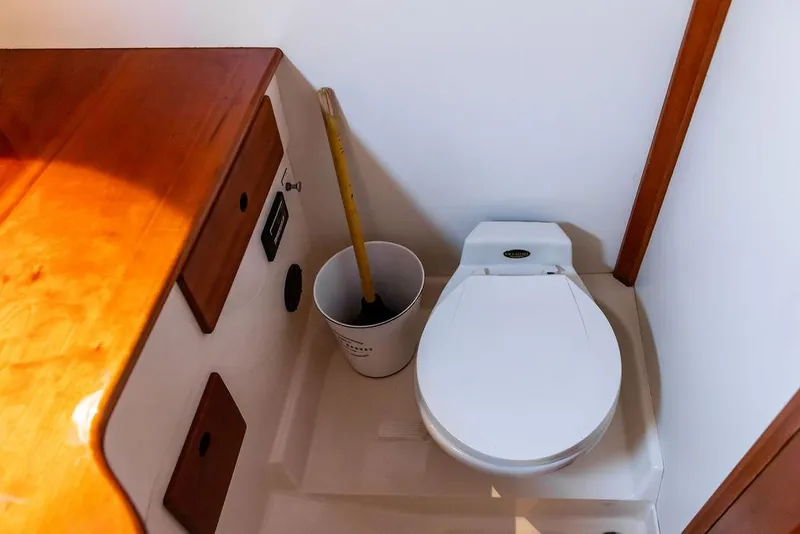 Slide: The Image of 1998 Hinckley Picnic Boat interior with toilet and wooden cabinetry. - 46