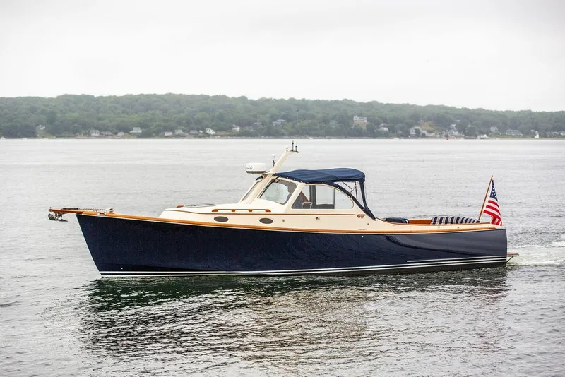 Slide: The Image of 1998 Hinckley Picnic Boat cruising on calm waters with American flag. - 1