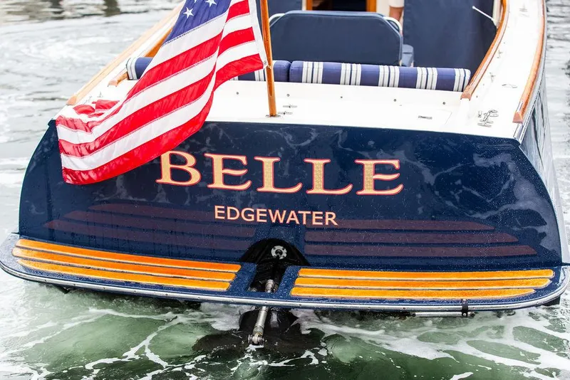 Slide: The Image of Hinckley 1998 Picnic Boat "Belle" with American flag on water. - 15