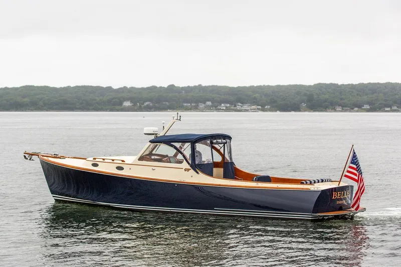 Slide: The Image of 1998 Hinckley Picnic Boat cruising on calm waters with American flag. - 2