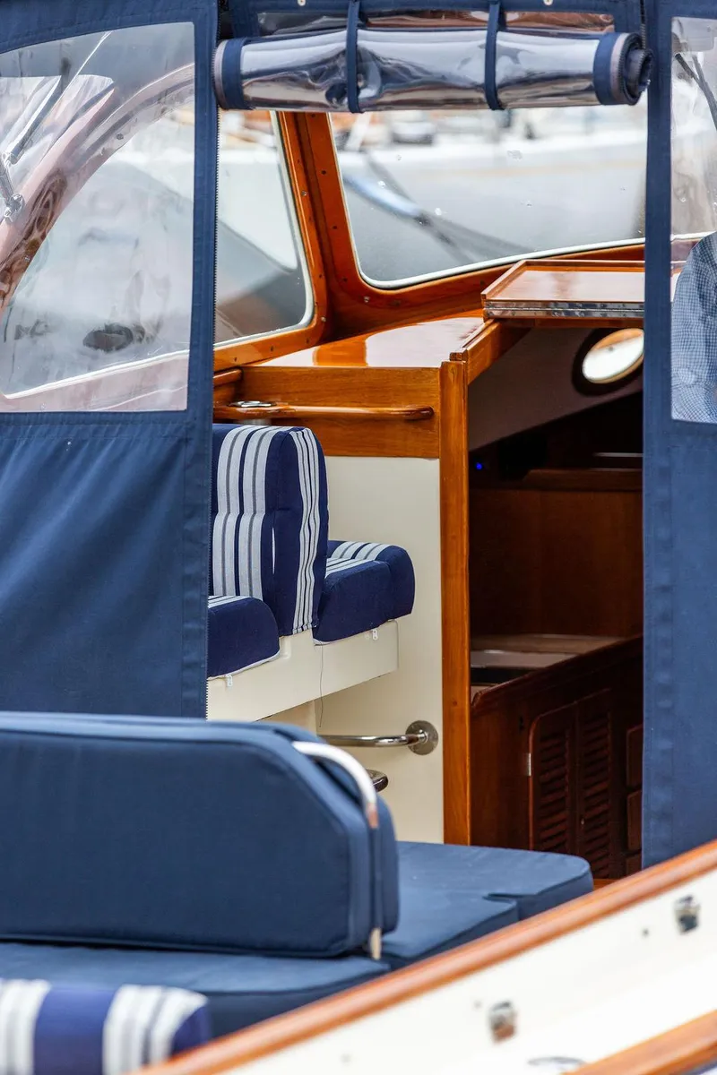 Slide: The Image of 1998 Hinckley Picnic Boat interior with blue and white striped seating and wooden accents. - 25