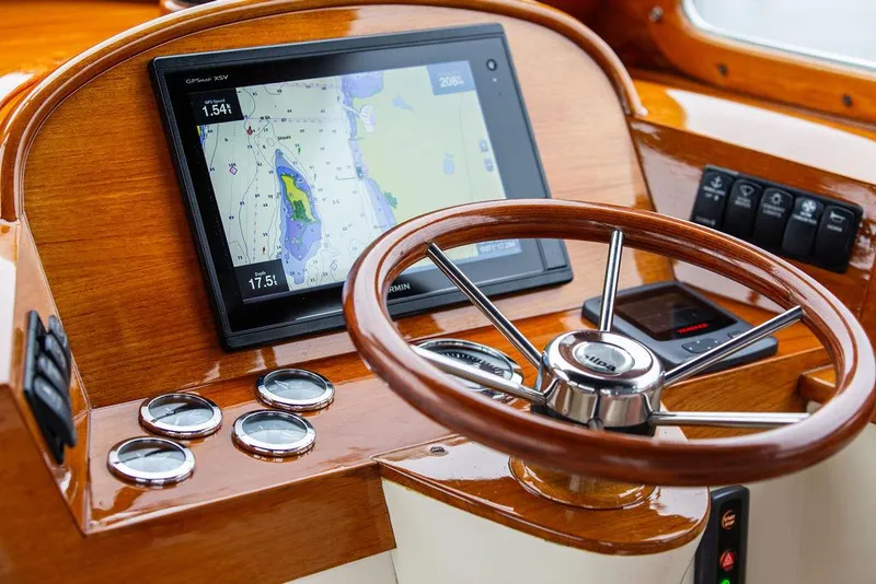 Slide: The Image of 1998 Hinckley Picnic Boat dashboard with GPS navigation and wooden steering wheel. - 28