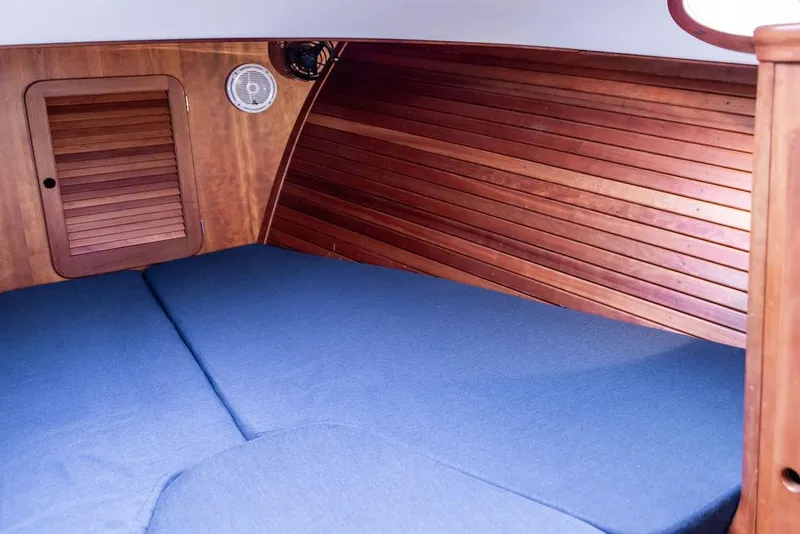 Slide: The Image of 1998 Hinckley Picnic Boat interior with wooden paneling and blue cushioned seating. - 40