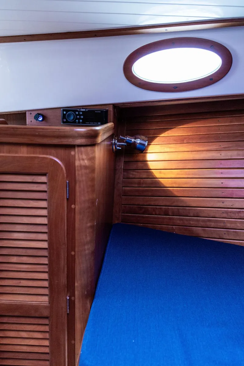 Slide: The Image of Interior of 1998 Hinckley Picnic Boat with wooden cabinetry and blue upholstery. - 41