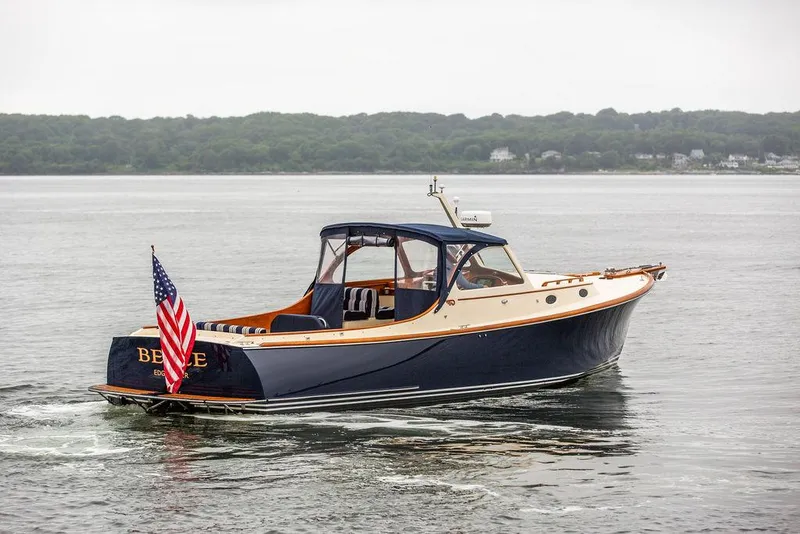 Slide: The Image of 1998 Hinckley Picnic Boat cruising on calm waters with American flag. - 6