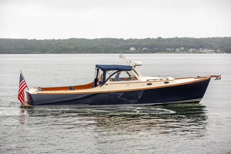 Slide: The Image of 1998 Hinckley Picnic Boat cruising on calm waters with American flag. - 7